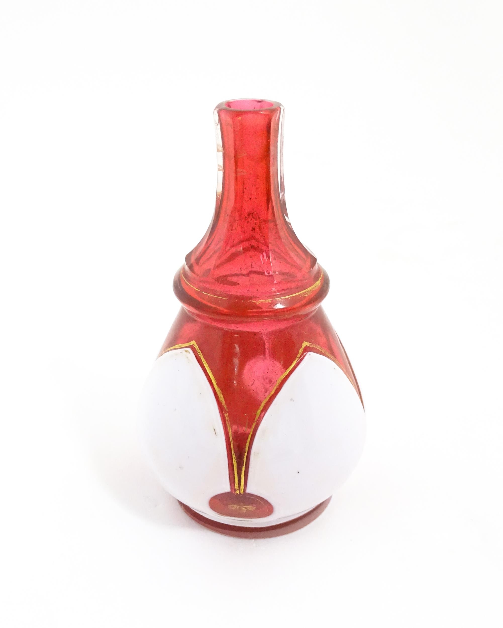 A small Bohemian style red and white glass bottle vase with gilt highlights. Approx. 3 3/4" high - Image 2 of 6