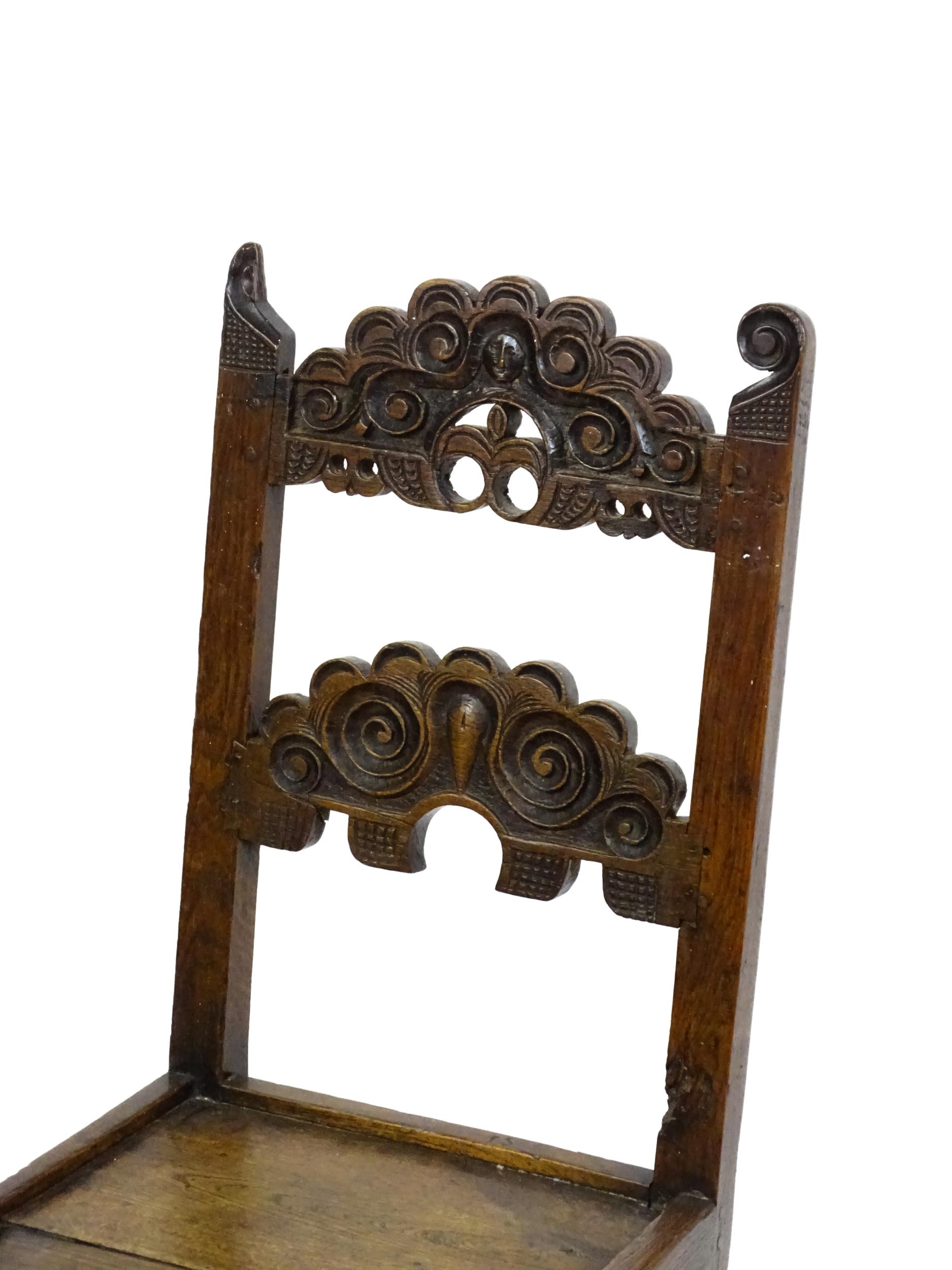 A 17thC oak peg jointed hall chair / back stool with a carved and scrolled top and mid rail raised - Image 5 of 7