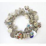 A silver charm bracelet set with various silver, white metal and silver plate charms Please Note -