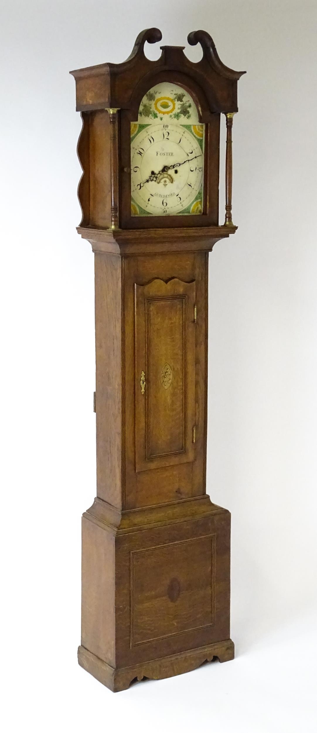A 19thC oak cased 8-day longcase clock. The painted arch dial signed Foster Guildford. The case with