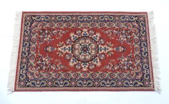 Carpet / Rug : A red ground rug with central floral motif, bordered by floral and foliate scroll