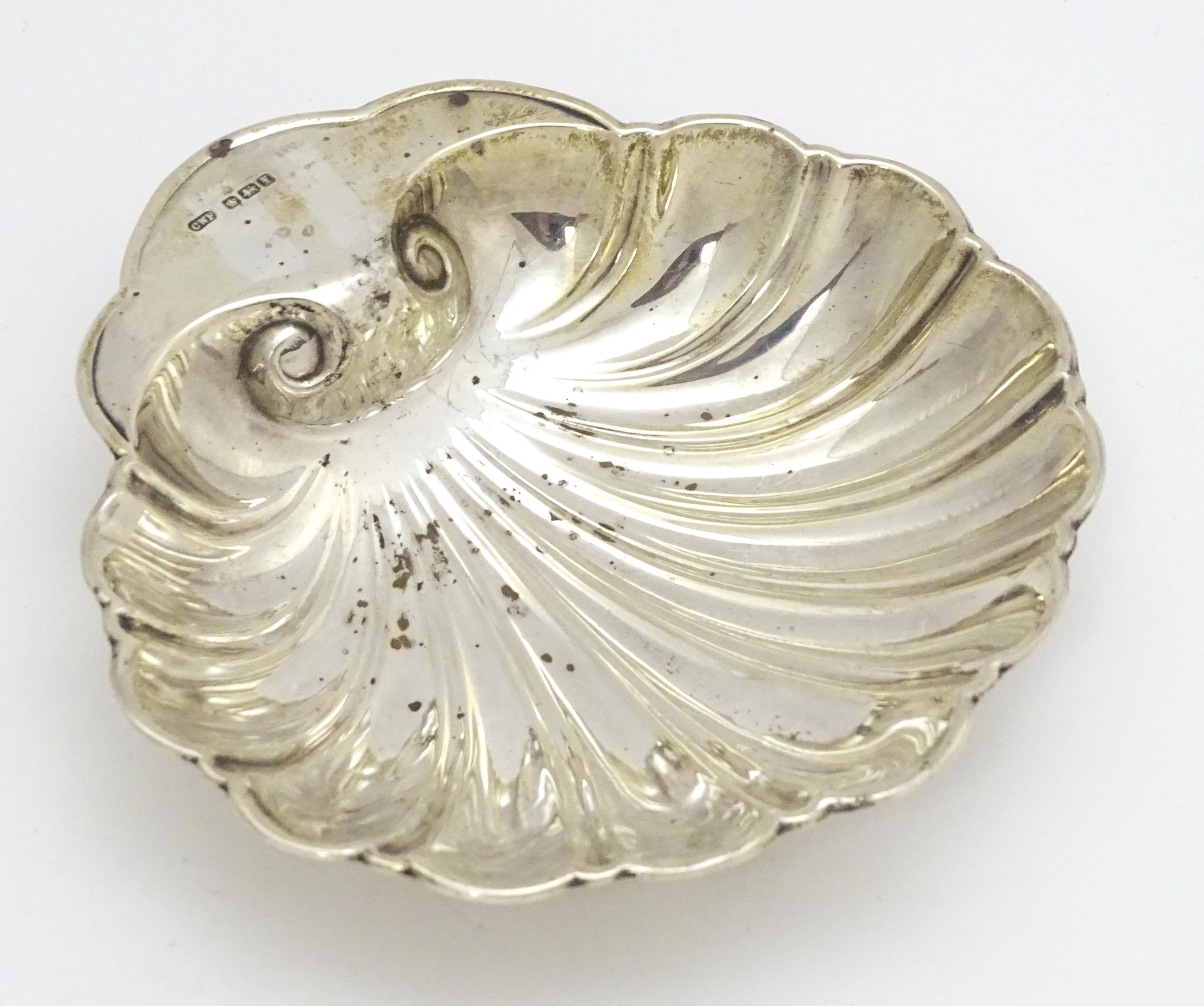 A silver butter dish of scallop shell form hallmarked Sheffield 1915, maker C. W. Fletcher & Son