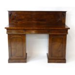 A Victorian mahogany double pedestal sideboard with a panelled upstand, acanthus carved brackets and