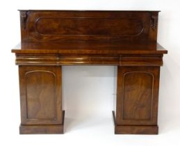 A Victorian mahogany double pedestal sideboard with a panelled upstand, acanthus carved brackets and