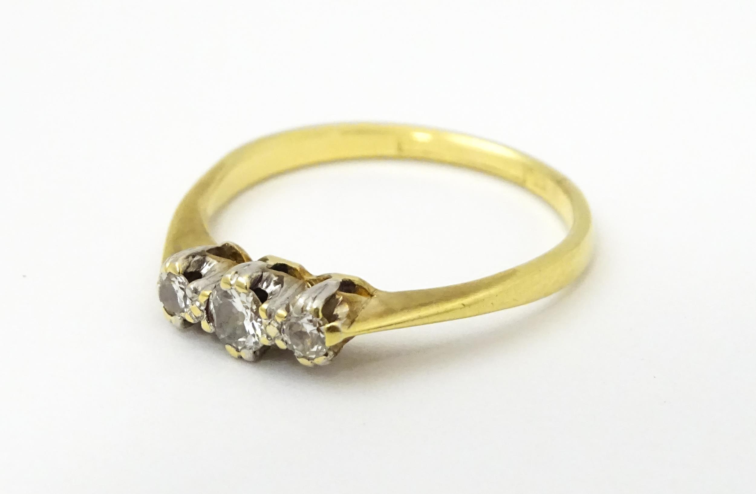 A gold ring set with a trio of diamonds in a platinum setting. Ring size approx. M Please Note - - Image 4 of 6