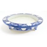 A Chinese blue and white stand of circular form raised on three feet decorated with prunus