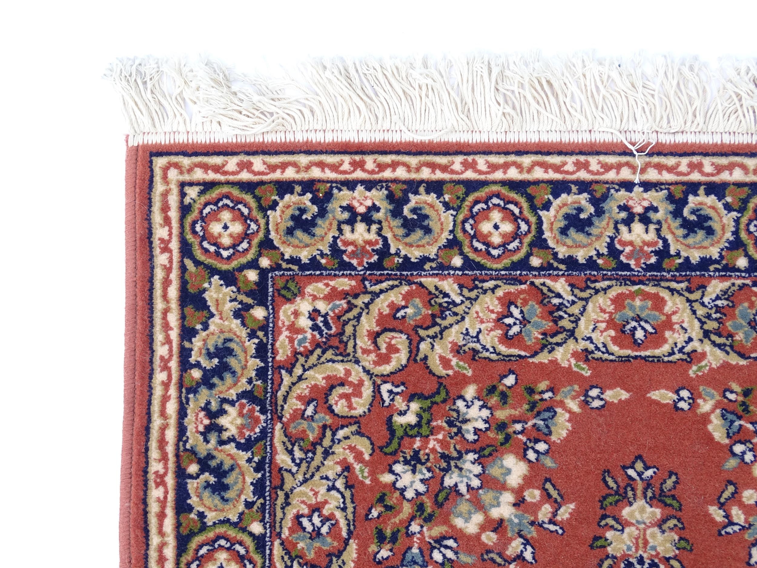 Carpet / Rug : A red ground rug with central floral motif, bordered by floral and foliate scroll - Image 3 of 7