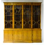 A yew wood veneered bookcase with a moulded cornice above four astragal glazed doors containing