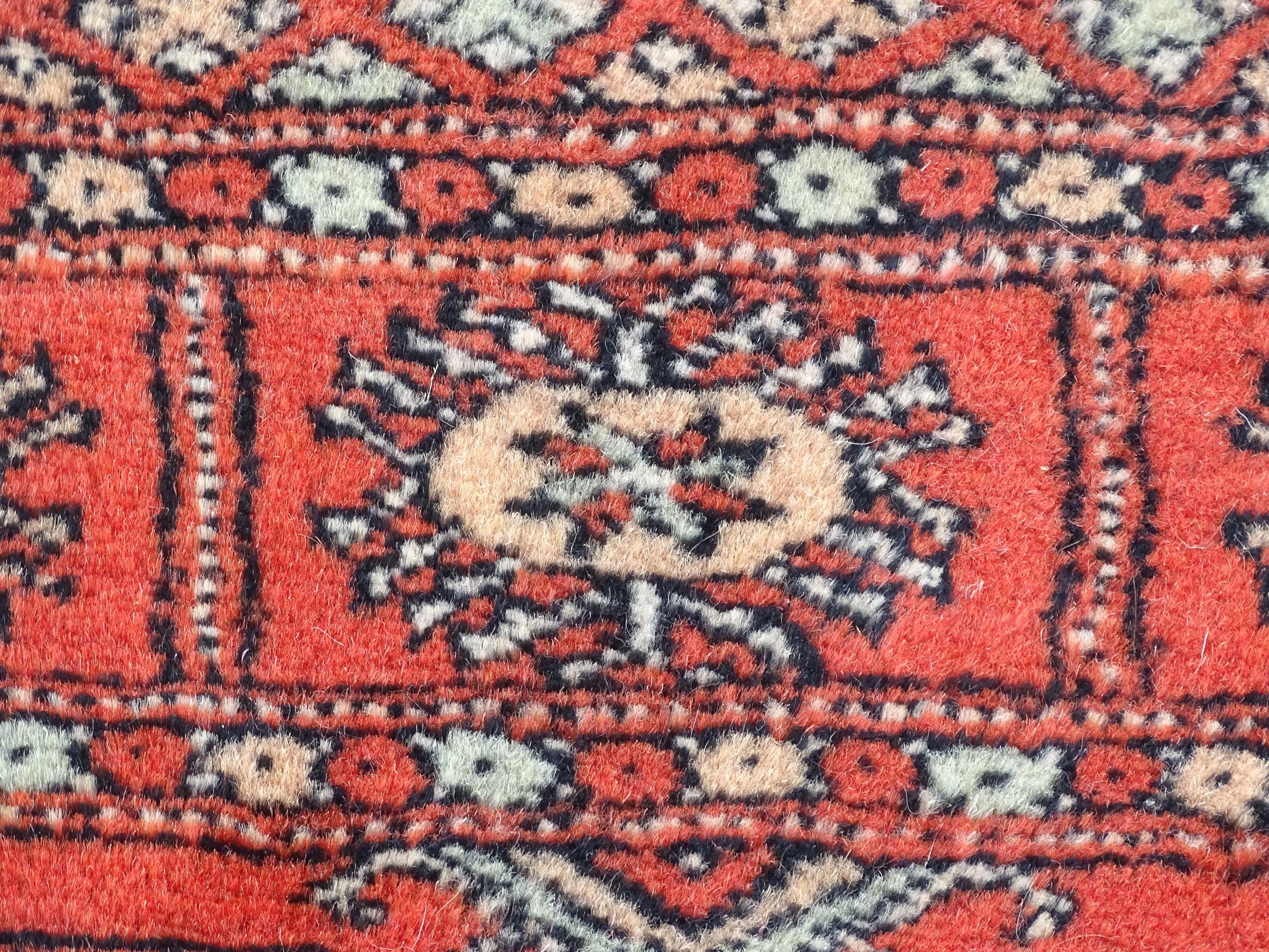 Carpet / Rug : A Pakistan wool red ground rug decorated with repeating geometric motifs with further - Image 4 of 8