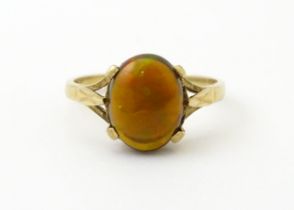 A 9ct gold ring set with fire opal cabochon. Ring size approx. R. Please Note - we do not make