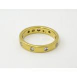A yellow metal eternity ring set with white stones. Ring size approx. Q 1/2 Please Note - we do