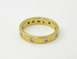 A yellow metal eternity ring set with white stones. Ring size approx. Q 1/2 Please Note - we do