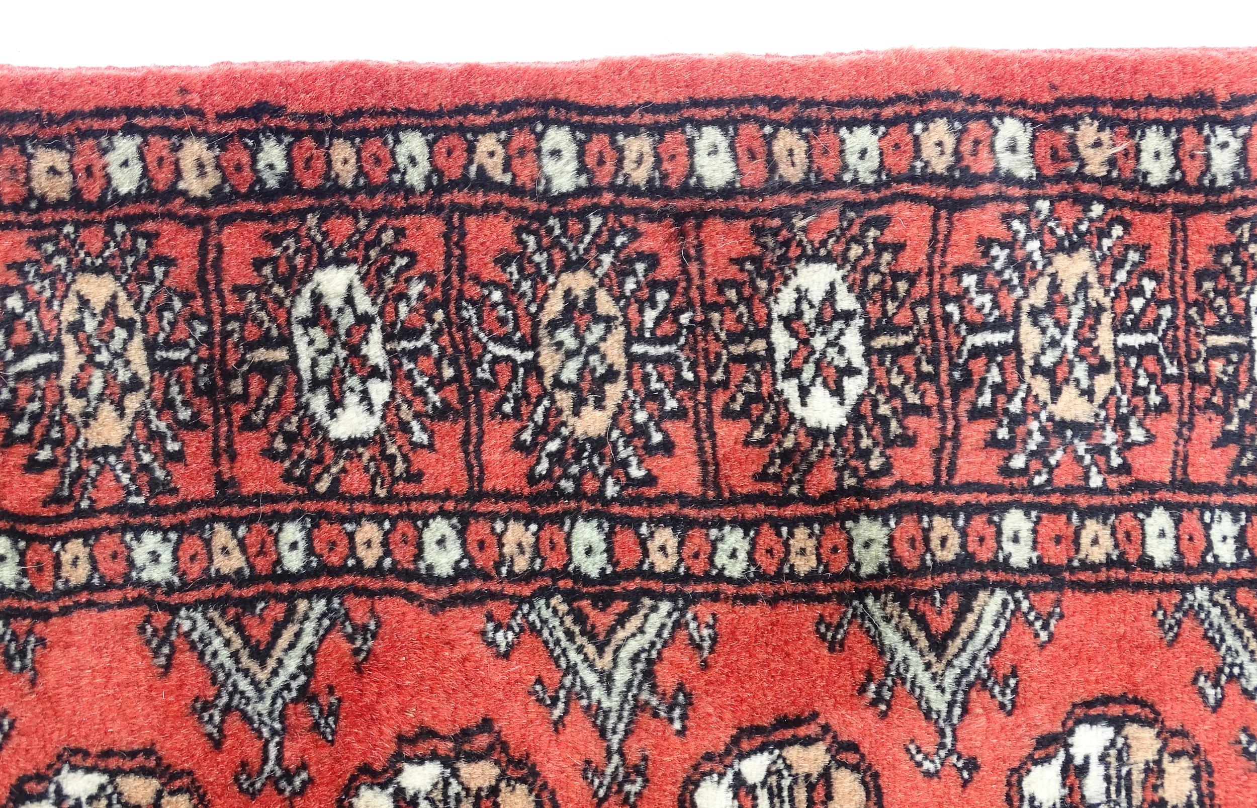 Carpet / Rug : A Pakistan wool red ground rug decorated with repeating geometric motifs with further - Image 5 of 8