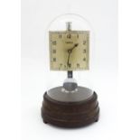 A Tempex electric clock mounted on a Bakelite base with chrome fitting. The squared dial with Arabic