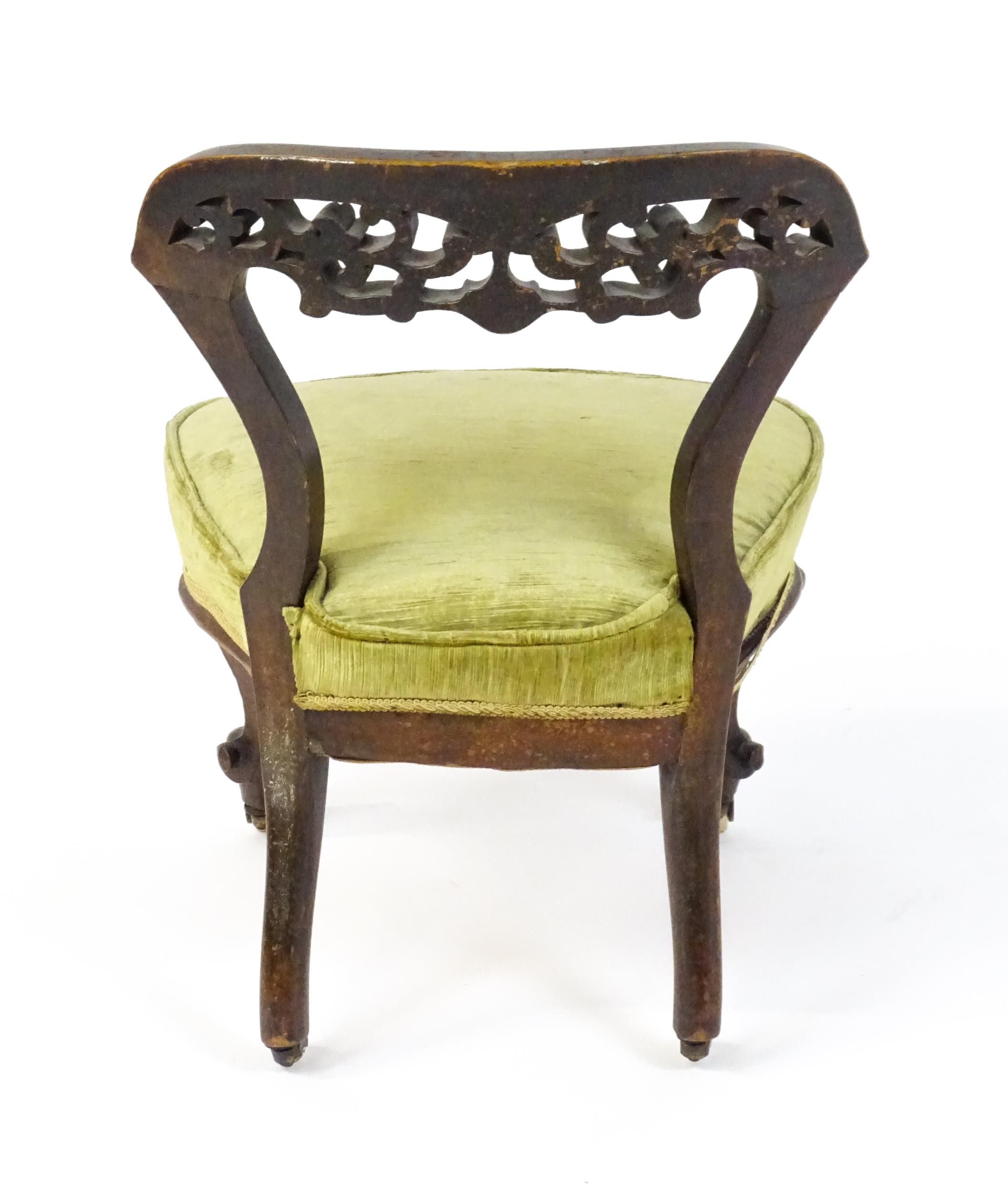 A mid / late 19thC mahogany nursing chair with a pierced, carved floral top rail above moulded - Image 6 of 6