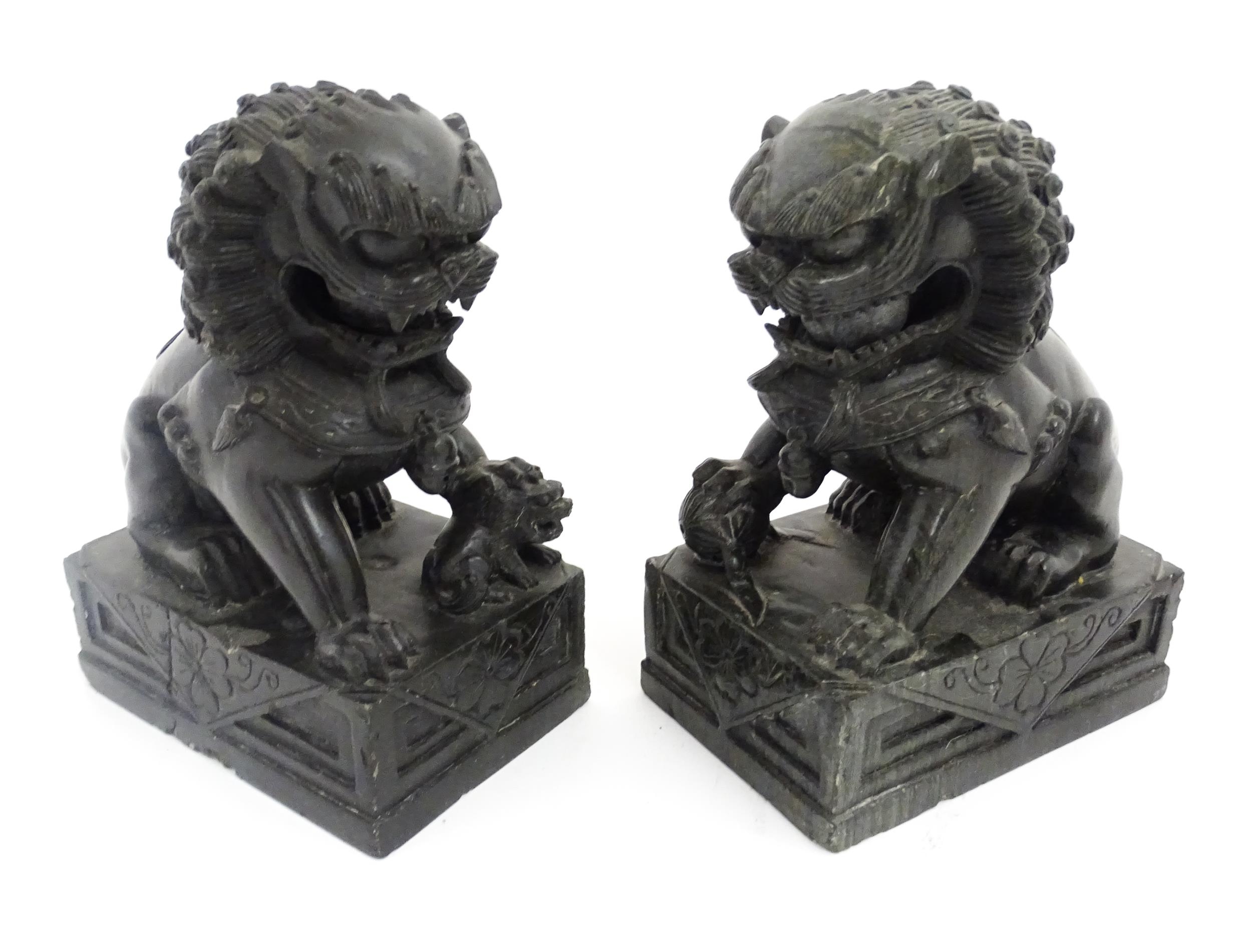 A pair of Chinese carved hardstone foo dogs / guardian lions with ball underfoot and loose ball