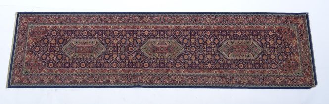 Carpet / Rug : A blue ground runner decorated with three central medallions with floral and scroll