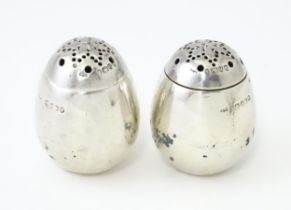 A pair of Victorian silver pepperettes of egg form. Hallmarked London 1883 maker William Hutton &