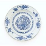 A Chinese blue and white plate decorated with flowers and foliage, with brushwork detail to reverse.