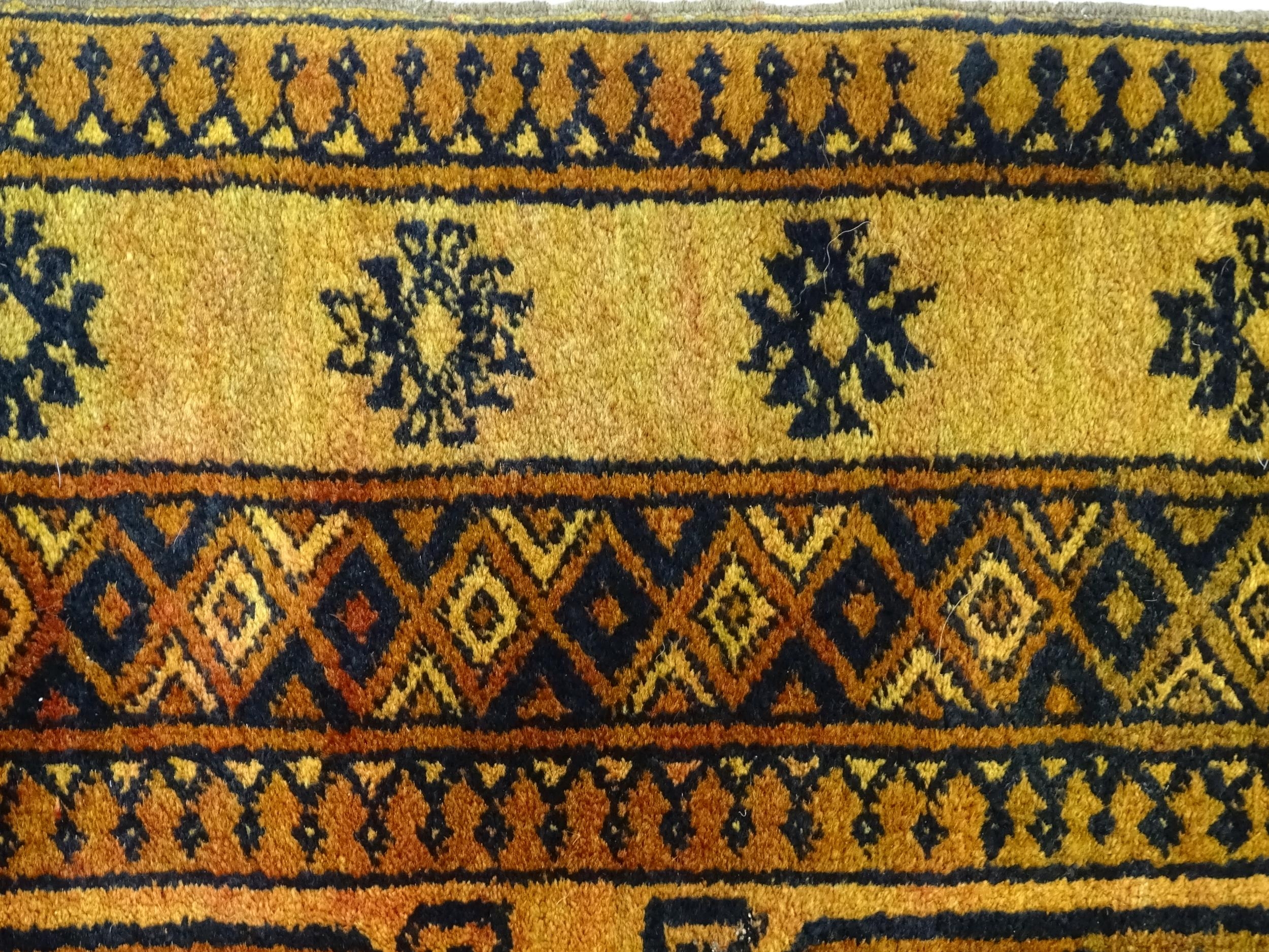 Carpet / Rug: An ochre ground rug decorated with centre vignettes with geometric motifs, further - Image 4 of 6