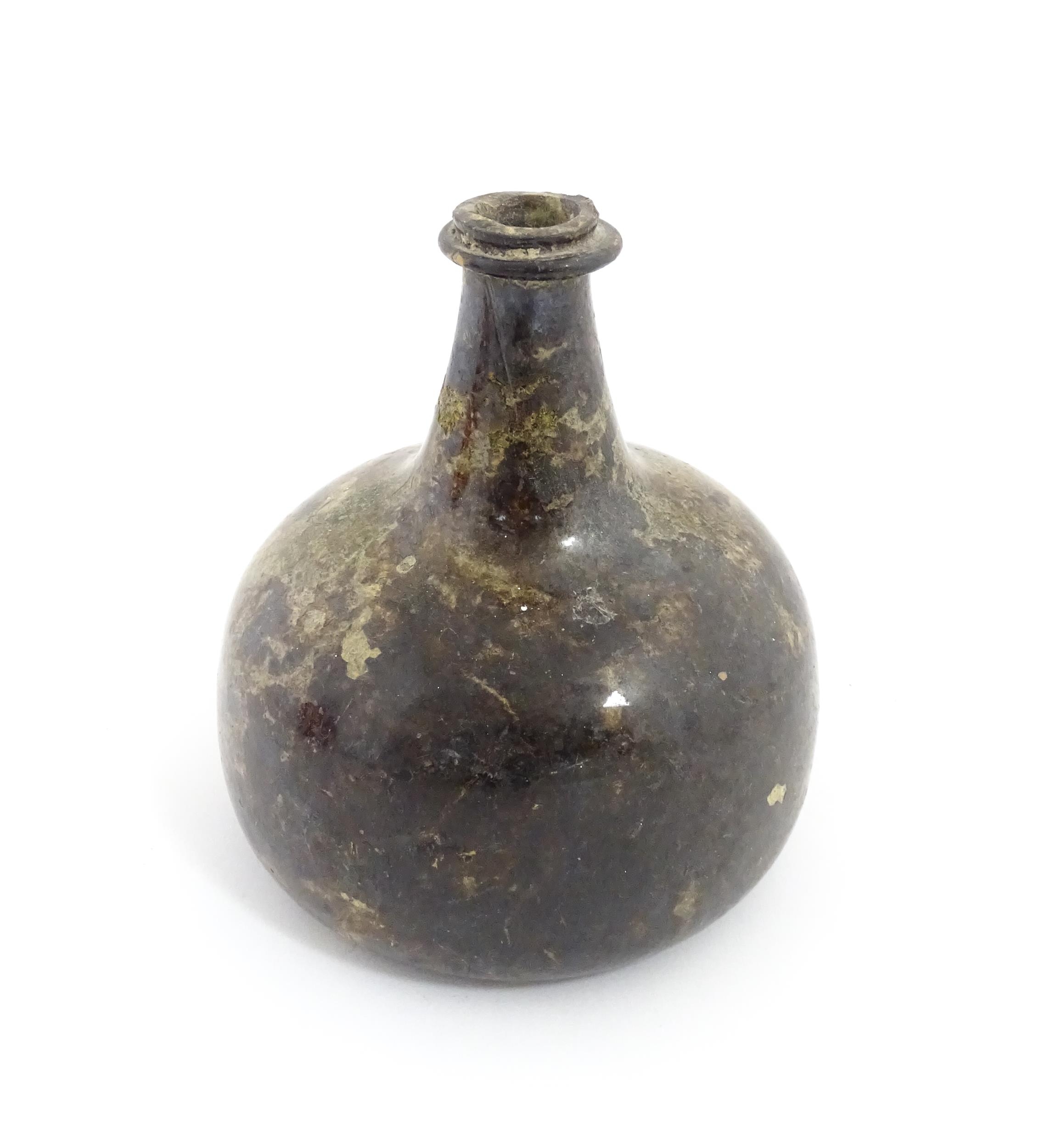 A late 18thC / early 19thC English dark olive green glass onion shape wine bottle. Approx. 6" high
