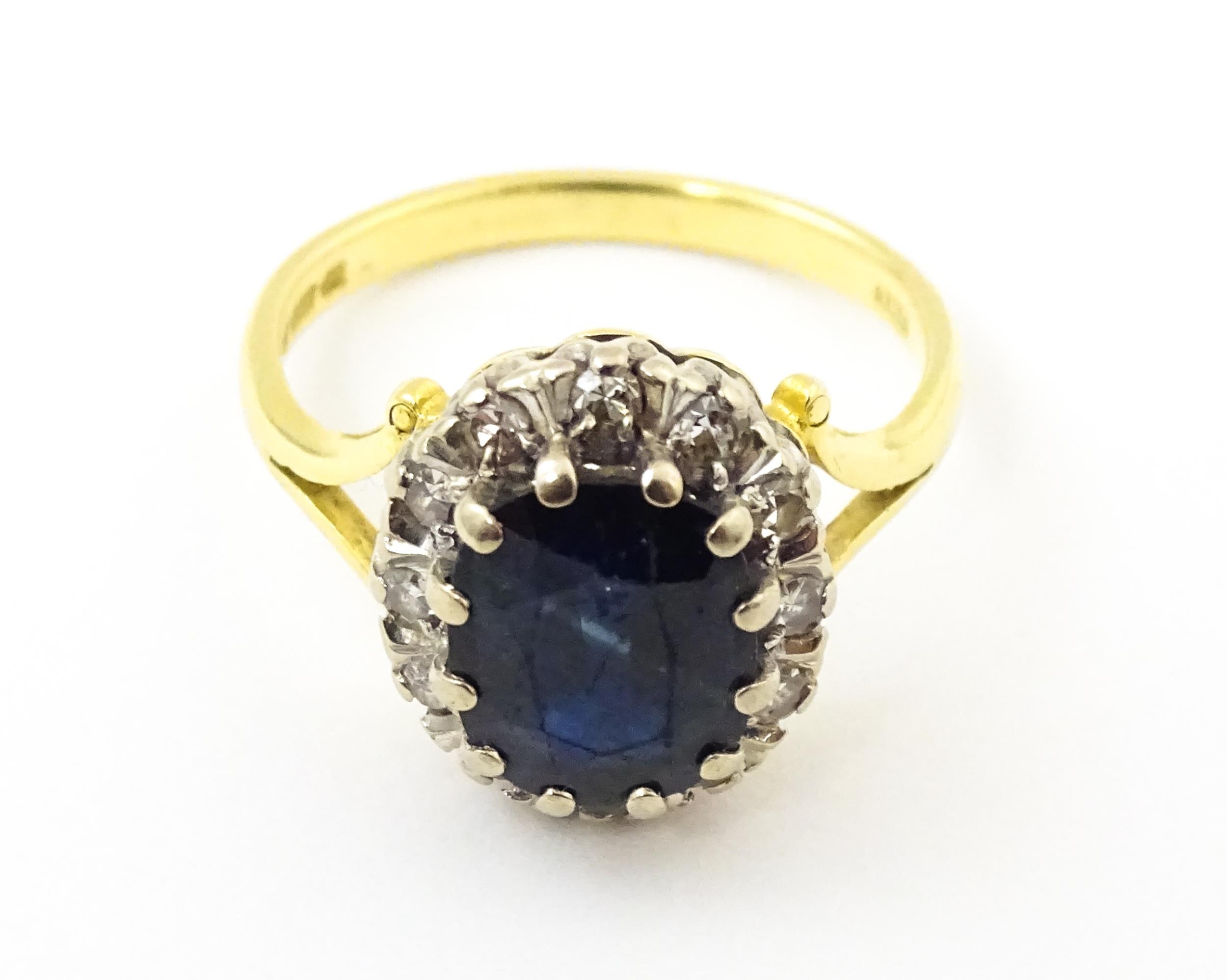 An 18ct gold ring set with central sapphire bordered by diamonds. Ring size approx. L 1/2 Please - Image 3 of 7