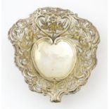 A silver bon bon dish / sweetmeat basket of stylised heart form with pierced, floral and acanthus