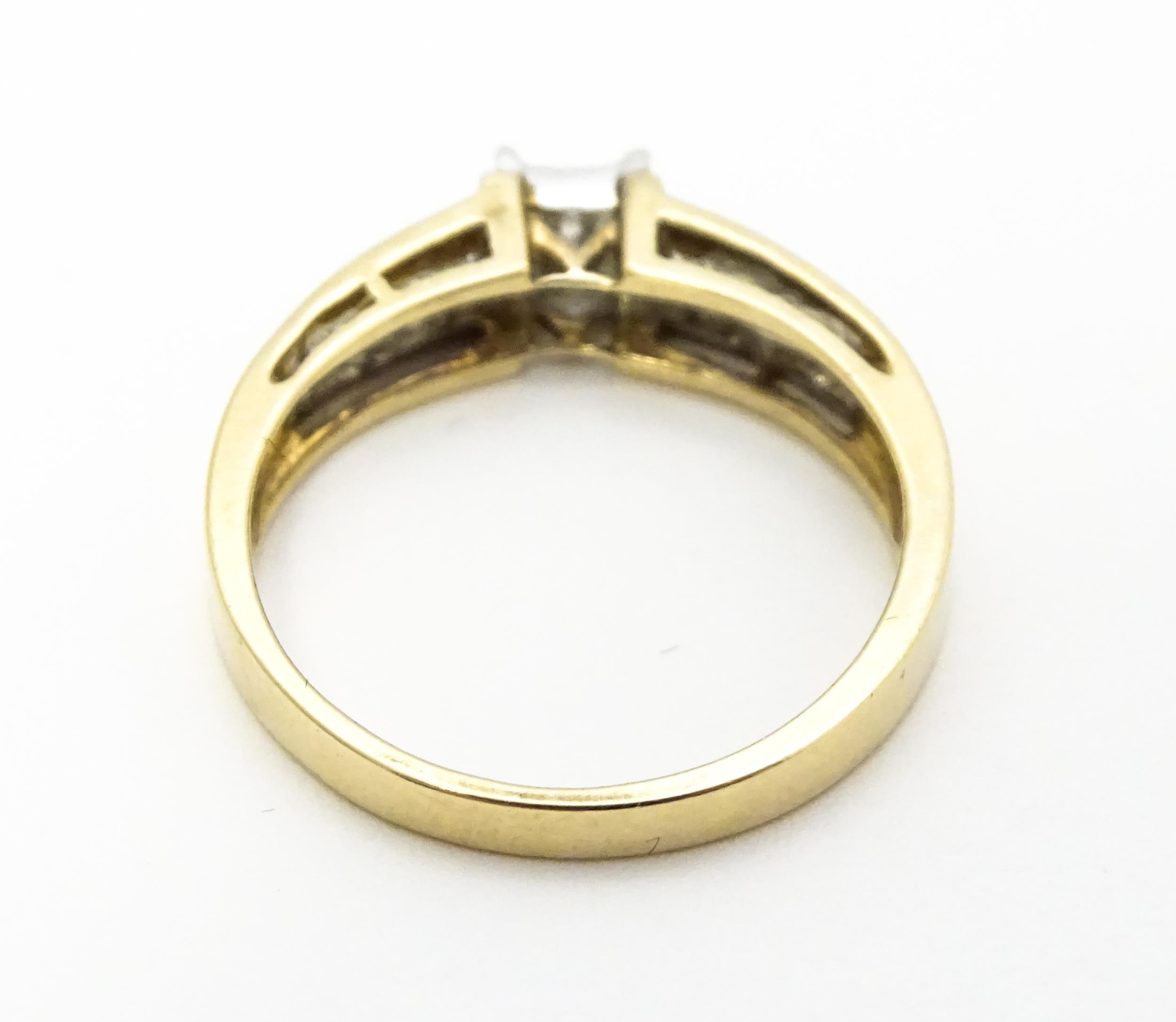 A 9ct gold ring set with 9 central diamonds flanked by a further 14 diamonds to each shoulder. - Image 6 of 8