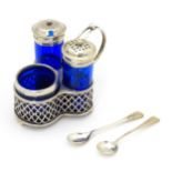 A silver cruet set with blue glass bottles, comprising stand, salt, pepper and mustard, hallmarked