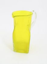 A 20thC yellow glass jug with squared base and clear glass handle. Approx. 8 1/2" high Please Note -
