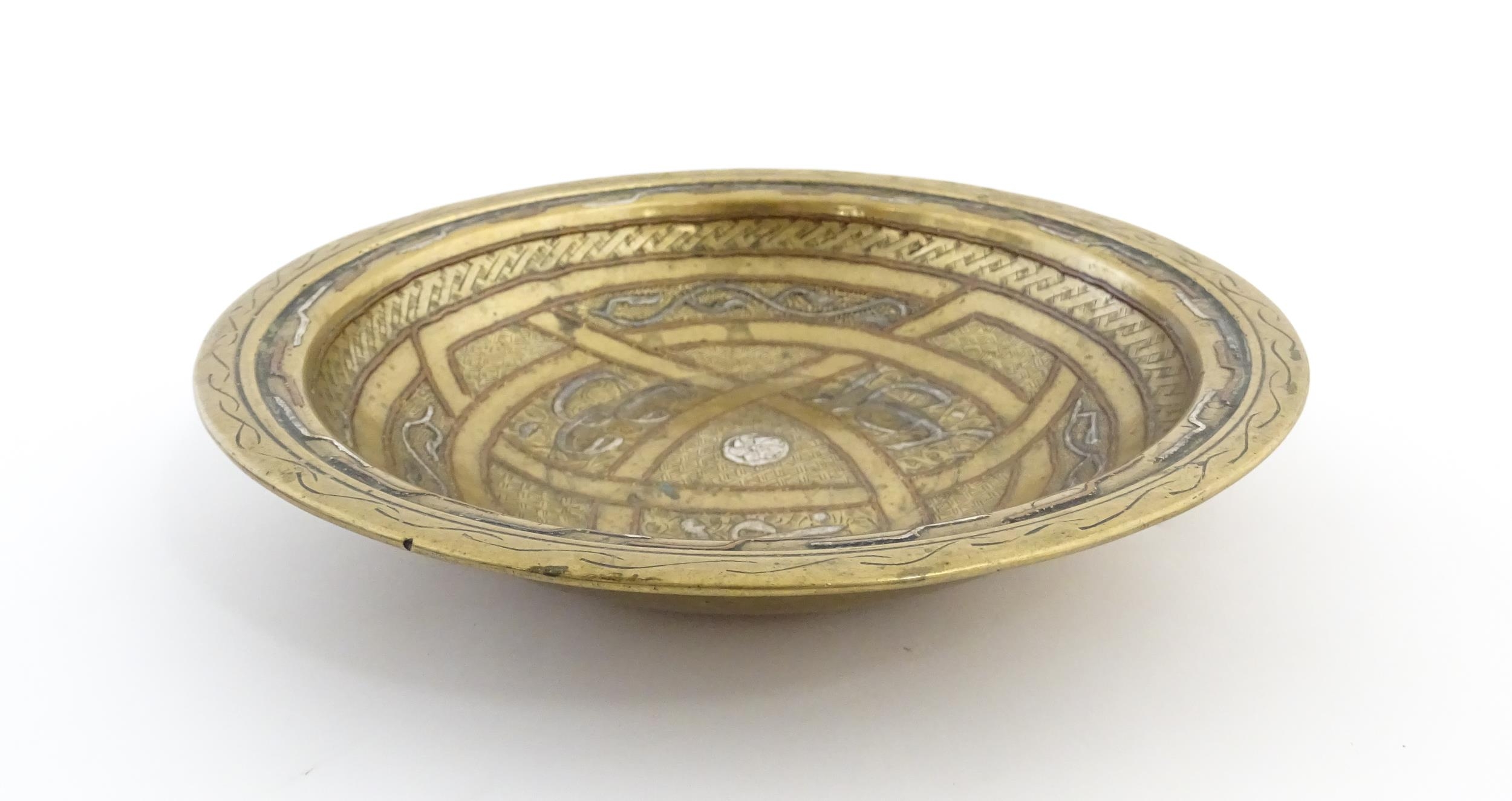A Middle Eastern brass dish / bowl with incised detail and inlaid white metal and copper - Image 5 of 8
