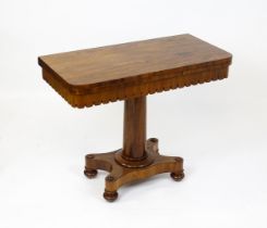 A 19thC mahogany tea table / card table with a hinged, revolving top above a turned pedestal and