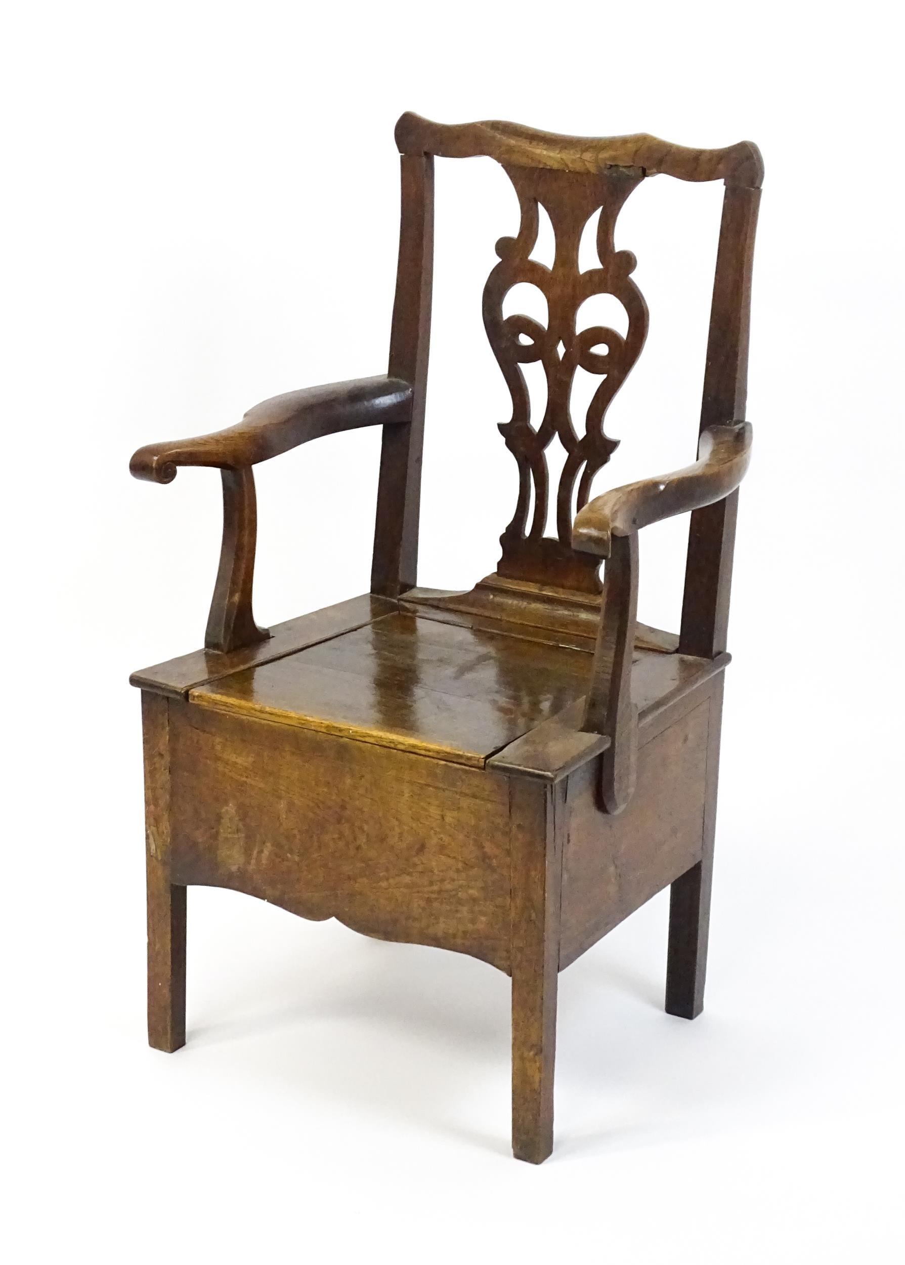 A late Georgian oak commode chair with a Chippendale style back splat above a hinged seat opening to - Image 7 of 10