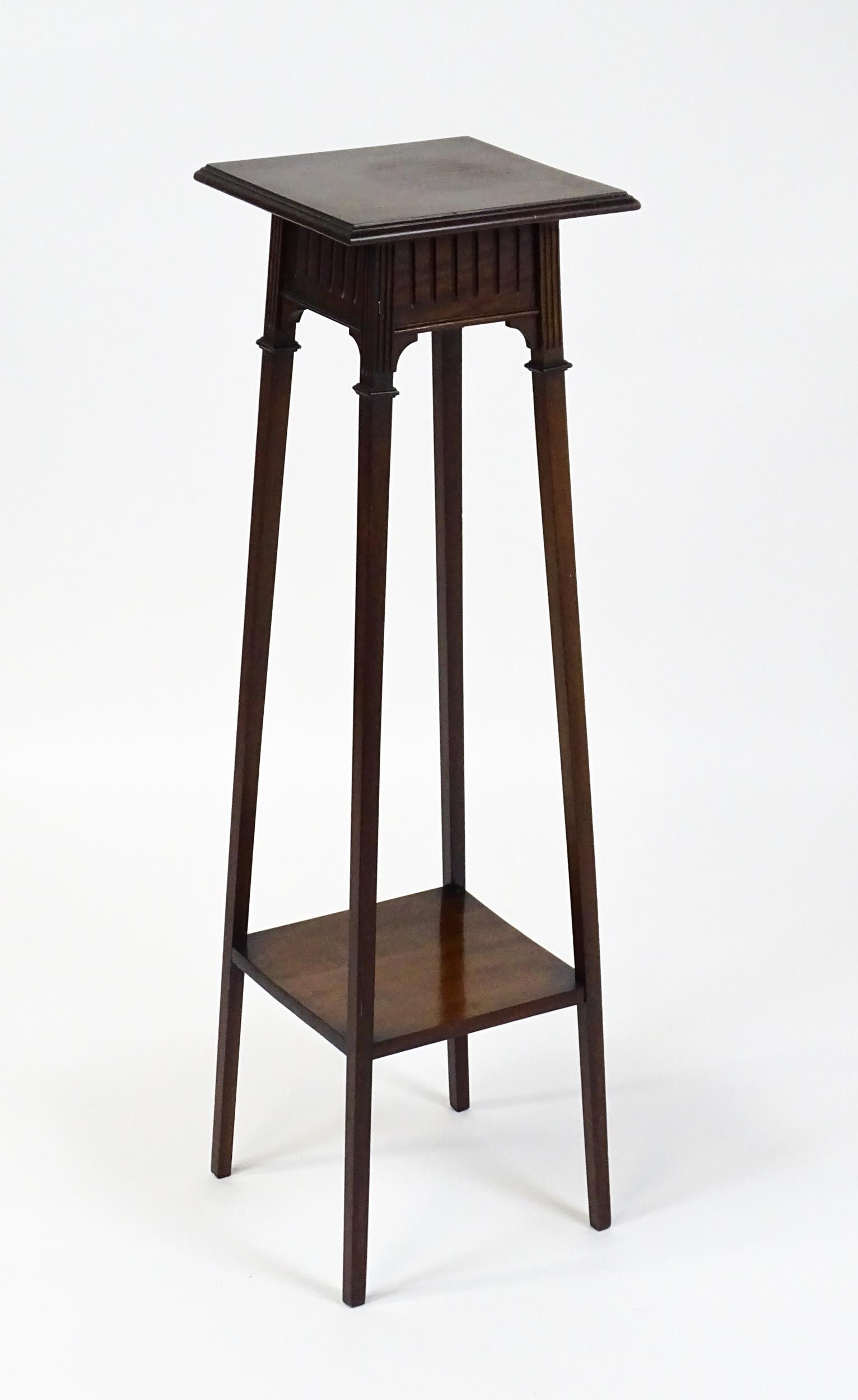 An early / mid 20thC mahogany jardinière stand with a moulded top above a fluted frieze raised on