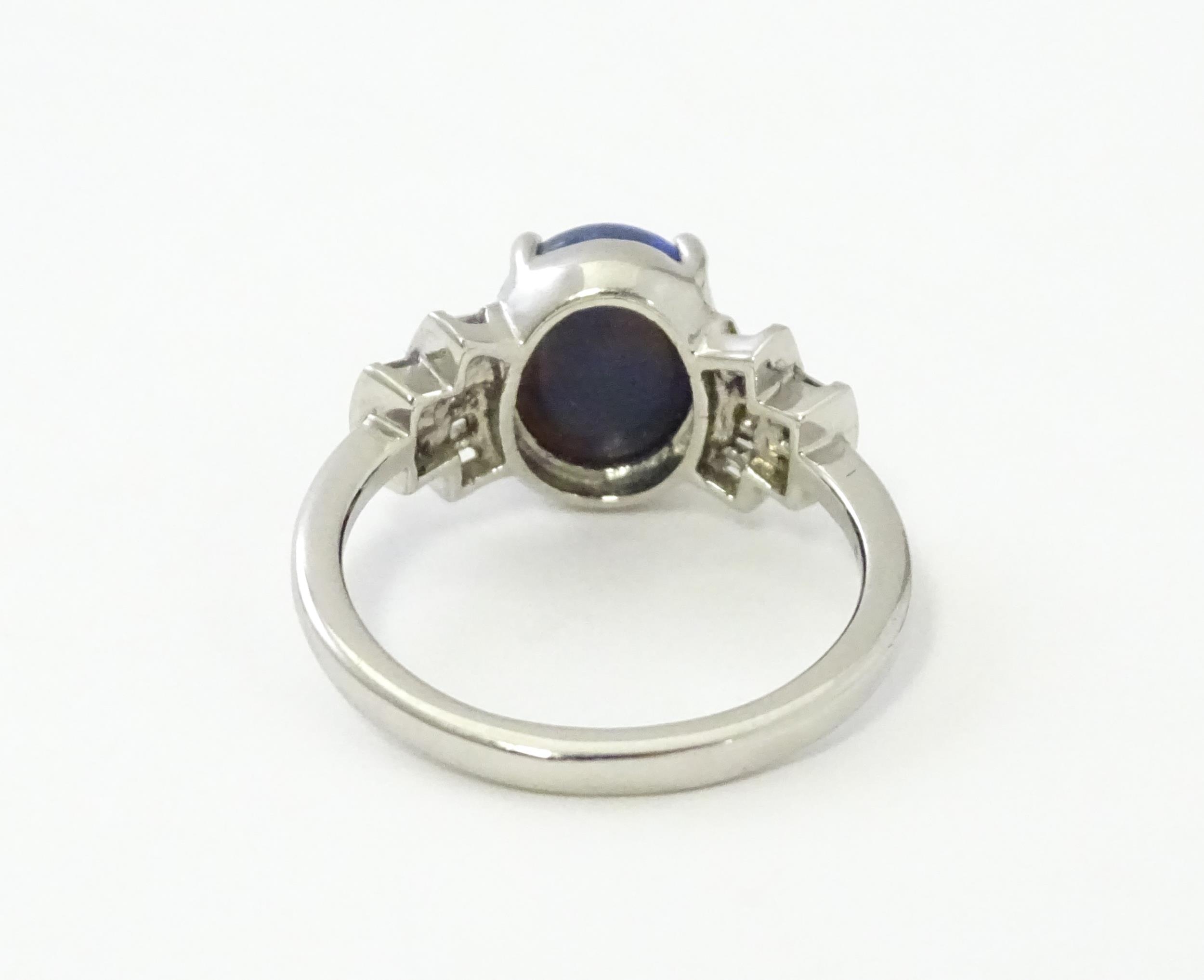 A platinum ring set with central black opal cabochon flanked by diamonds in an Art deco style - Image 6 of 9