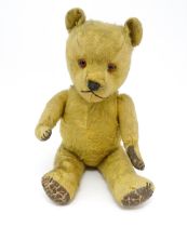 Toy: An early 20thC mohair straw filled teddy bear with stitched nose and mouth, articulated limbs