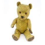 Toy: An early 20thC mohair straw filled teddy bear with stitched nose and mouth, articulated limbs