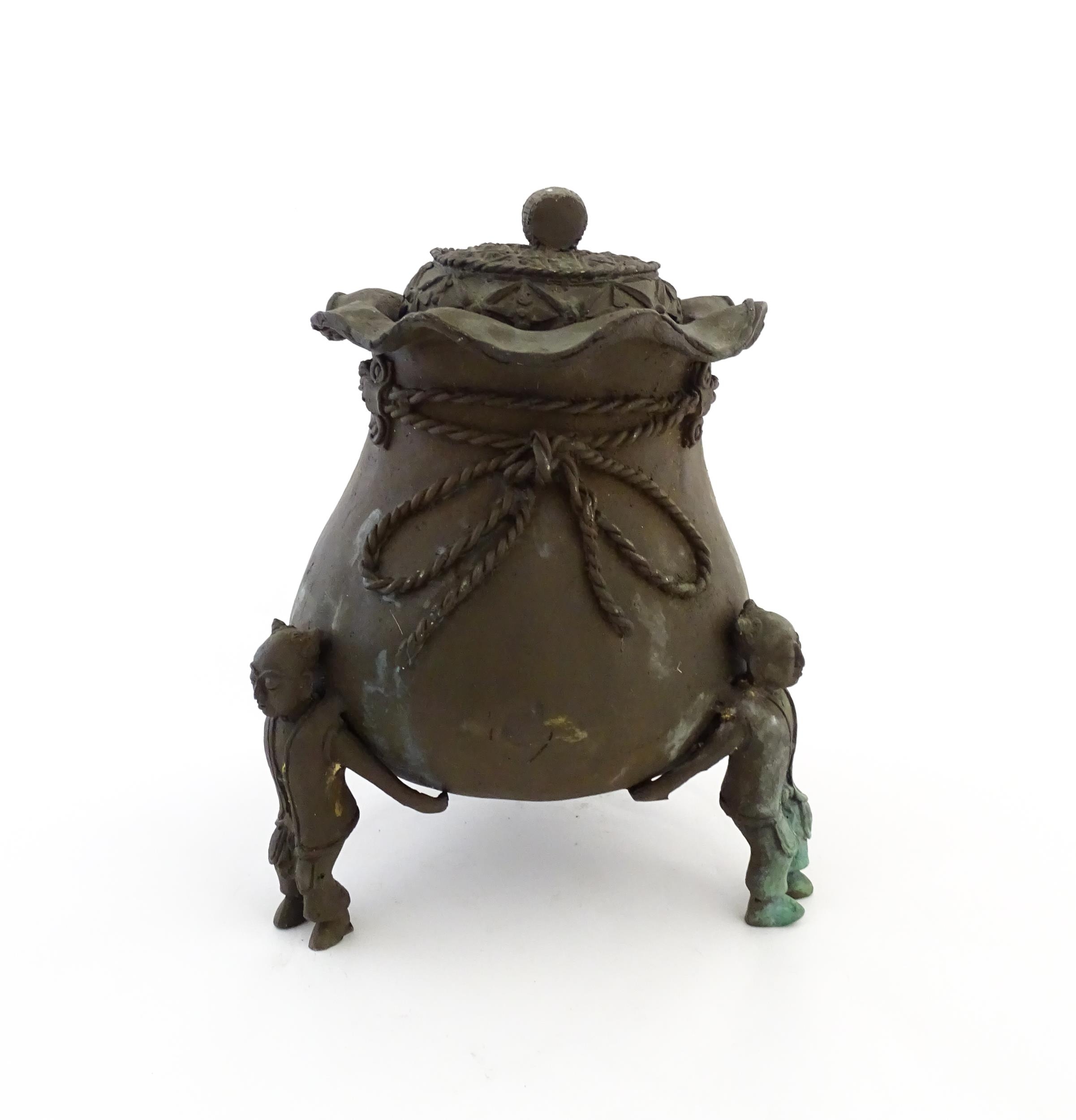 A Chinese cast bronze pot and cover modelled as a money bag with rope tie supported by three figural - Image 8 of 10