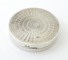 An Art Deco silver compact with engine turned decoration and mirror within, hallmarked Birmingham