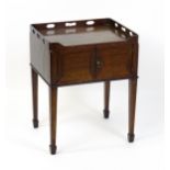 An 18thC mahogany bedside table / tray top cabinet with a pierced upstand above two hinged doors and