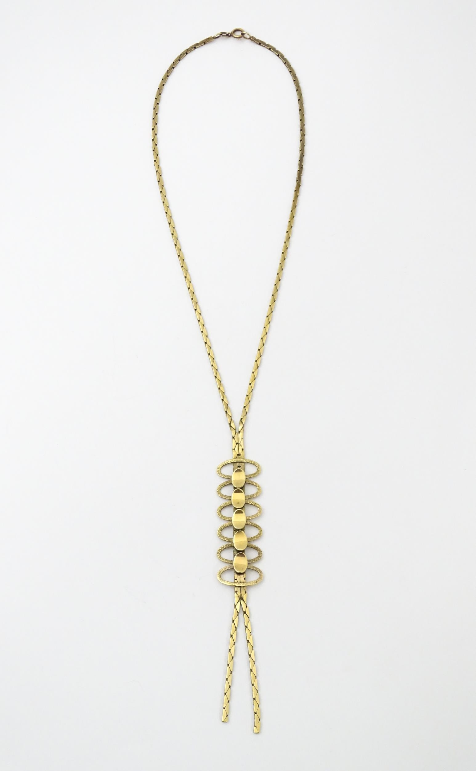 A 9ct gold necklace with textured oval detail to lower section. Bearing import marks for London