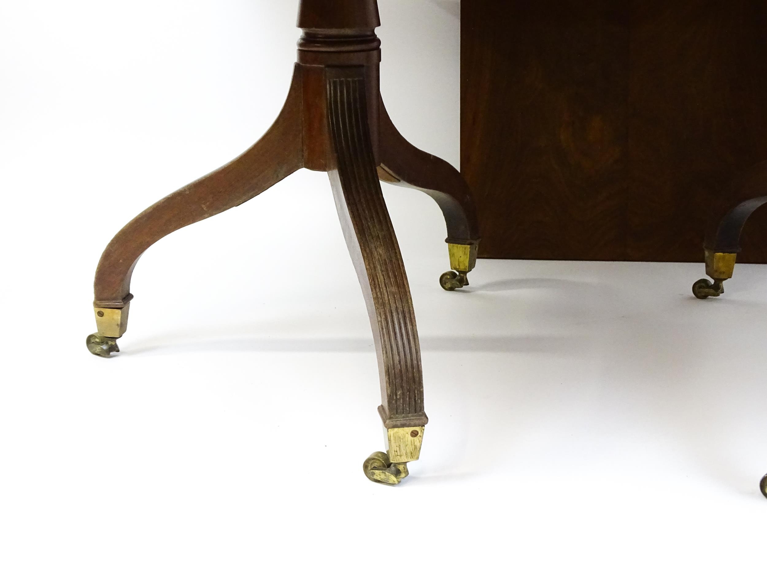 A Georgian mahogany double pedestal dining table raised on reeded legs terminating in brass caps and - Image 2 of 4