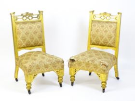 A pair of early 20thC giltwood nursing chairs with Anglo-Japanese pierced design elements and raised