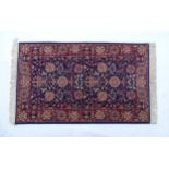 Carpet / Rug : A blue ground wool rug decorated with floral and foliate detail, further repeated