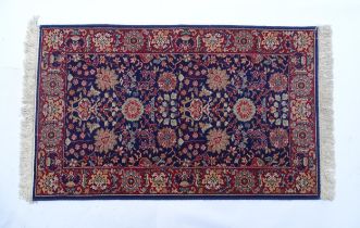 Carpet / Rug : A blue ground wool rug decorated with floral and foliate detail, further repeated