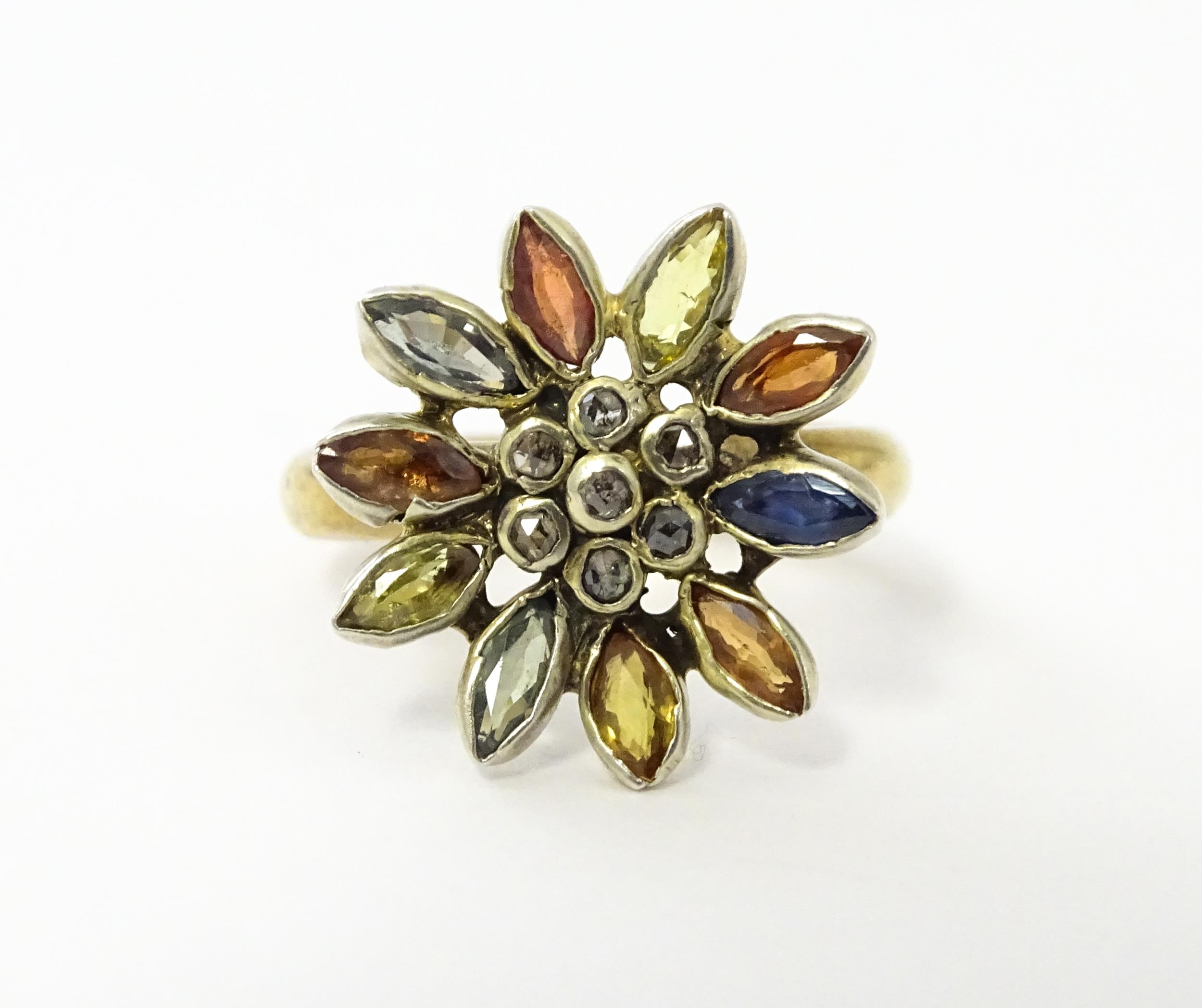 A 9ct gold ring set with central diamonds bordered by various coloured stones in a flower setting.