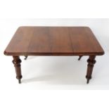 A 19thC mahogany dining table with a moulded top edge raised on four carved legs raised on four