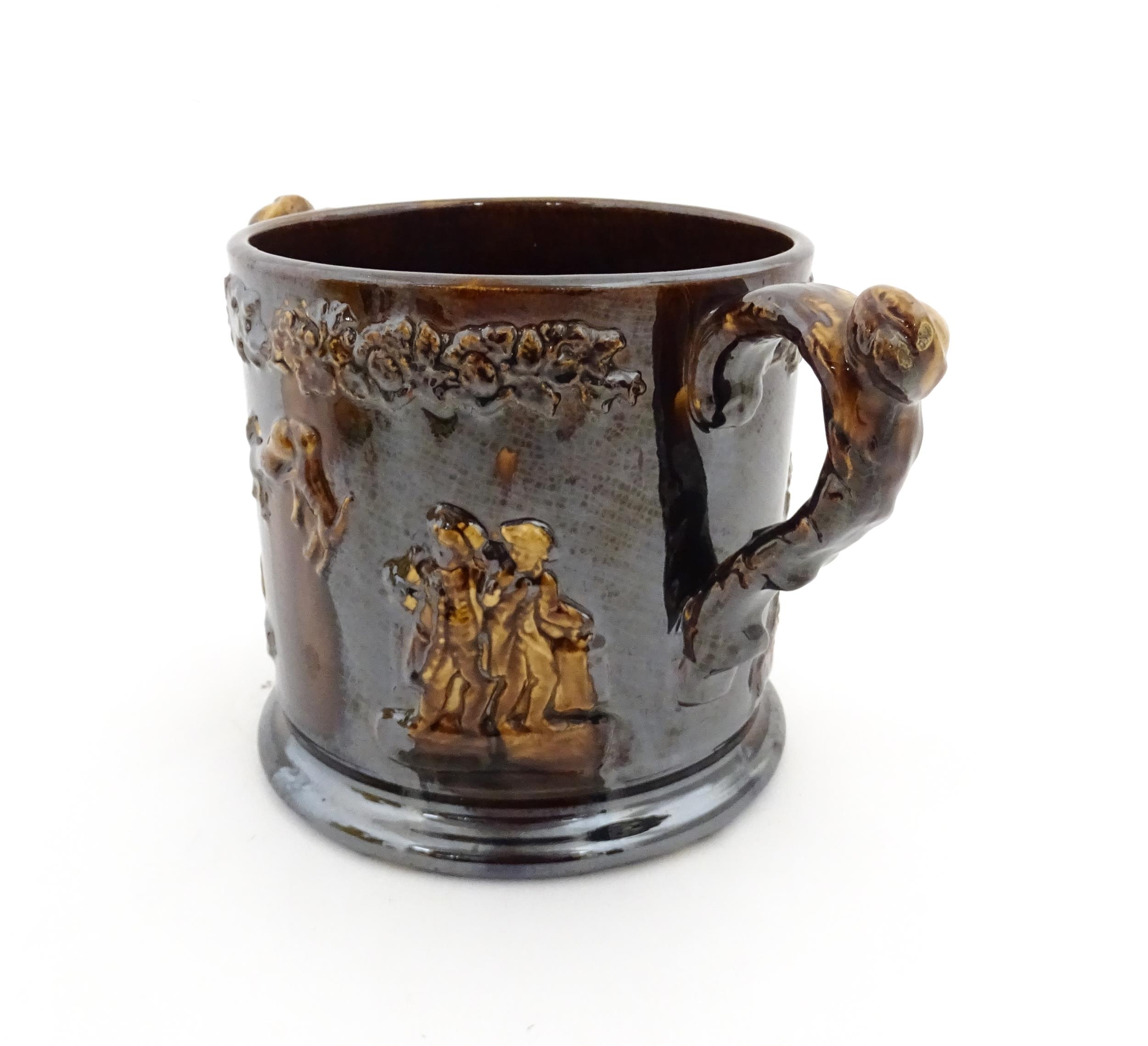 A large Staffordshire treacle glazed frog loving cup decorated in relief with depictions of - Image 6 of 9