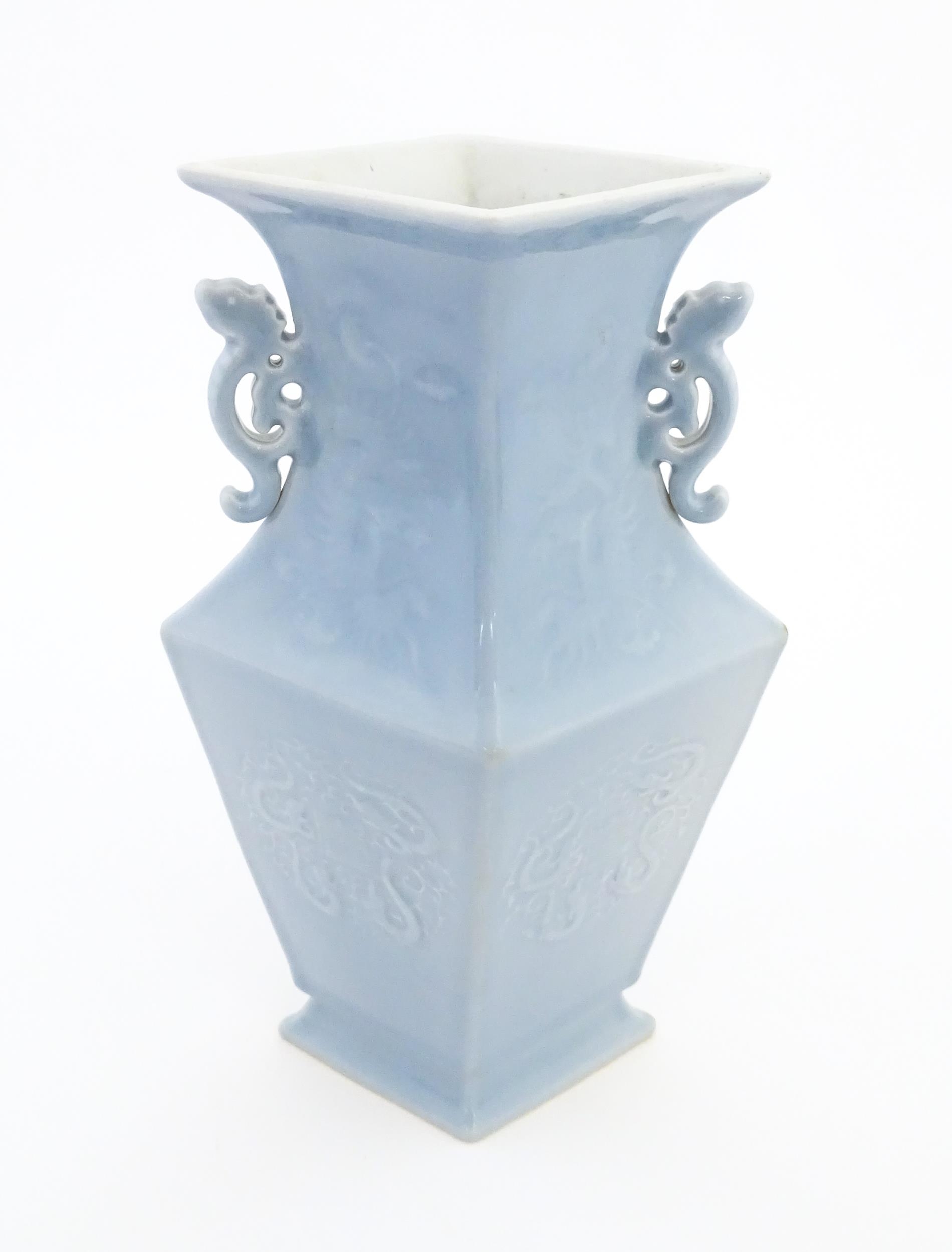 A Chinese vase of angular baluster form with a pale blue ground and twin handles, decorated with