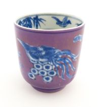 A Chinese cup with a purple ground decorated with birds, foliage and stylised clouds. Character